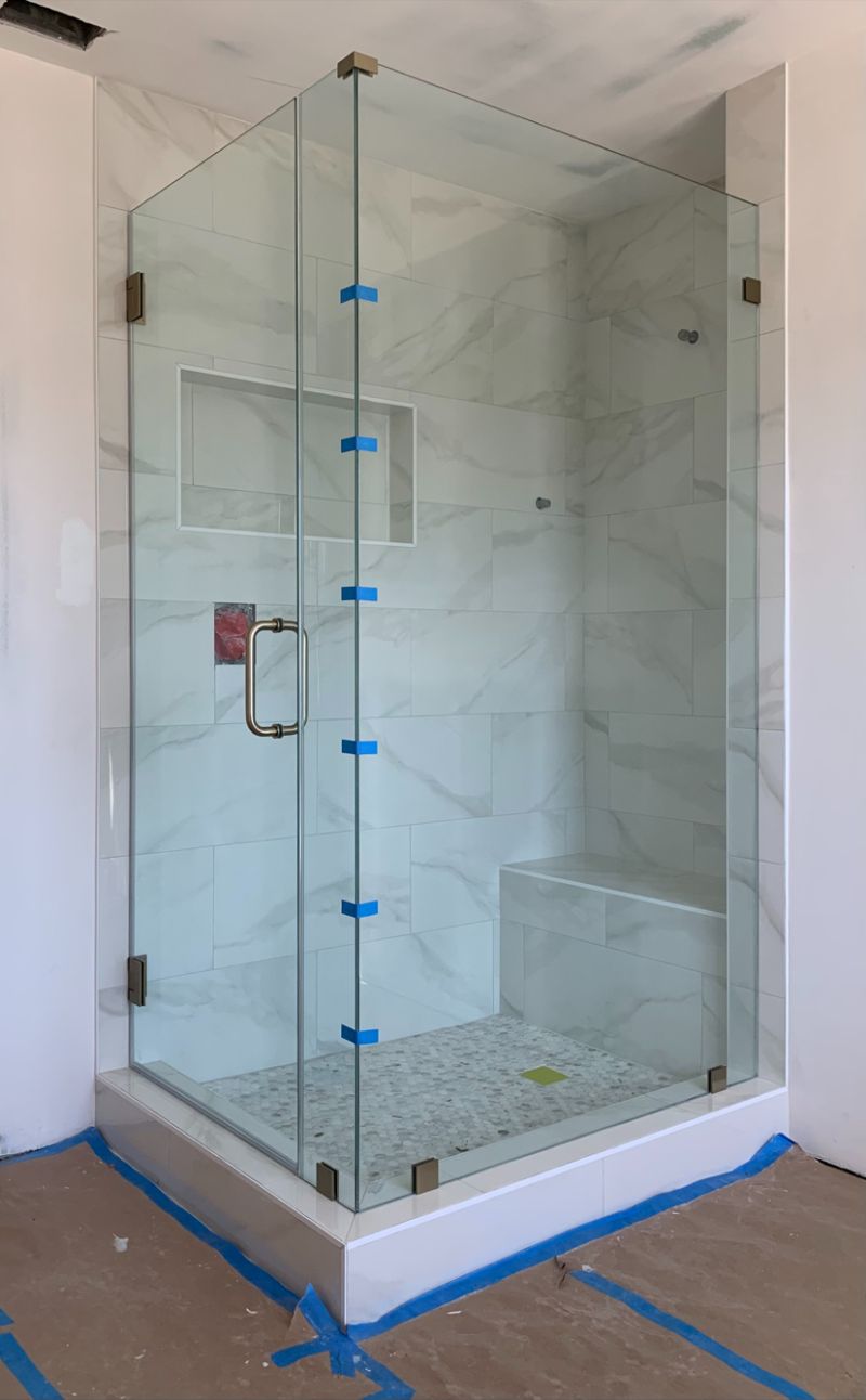 123-pound frameless corner shower panel with antique-brass hardware in Anaheim