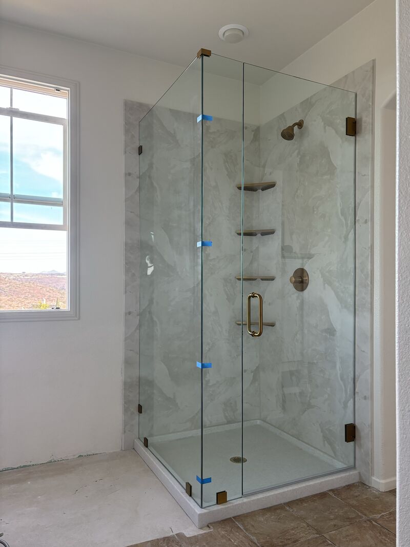 87-inch-tall frameless corner shower with brushed-gold hardware in Carlsbad