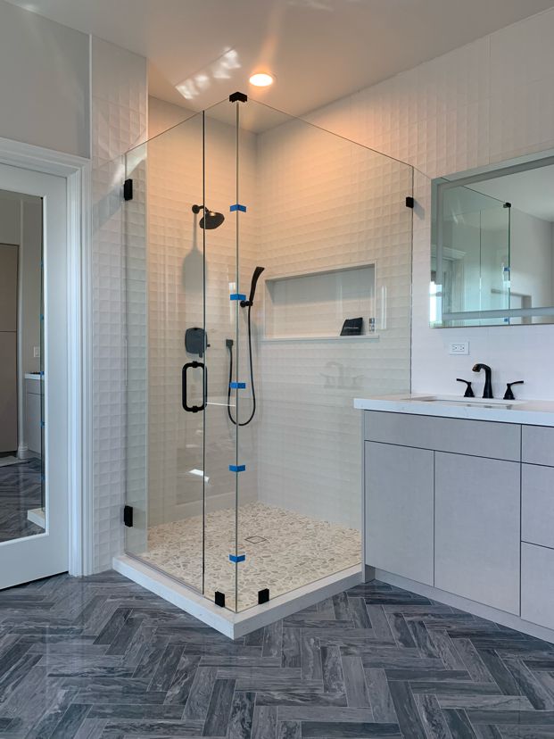 Frameless corner enclosure with an in-and-out swinging door in Carlsbad