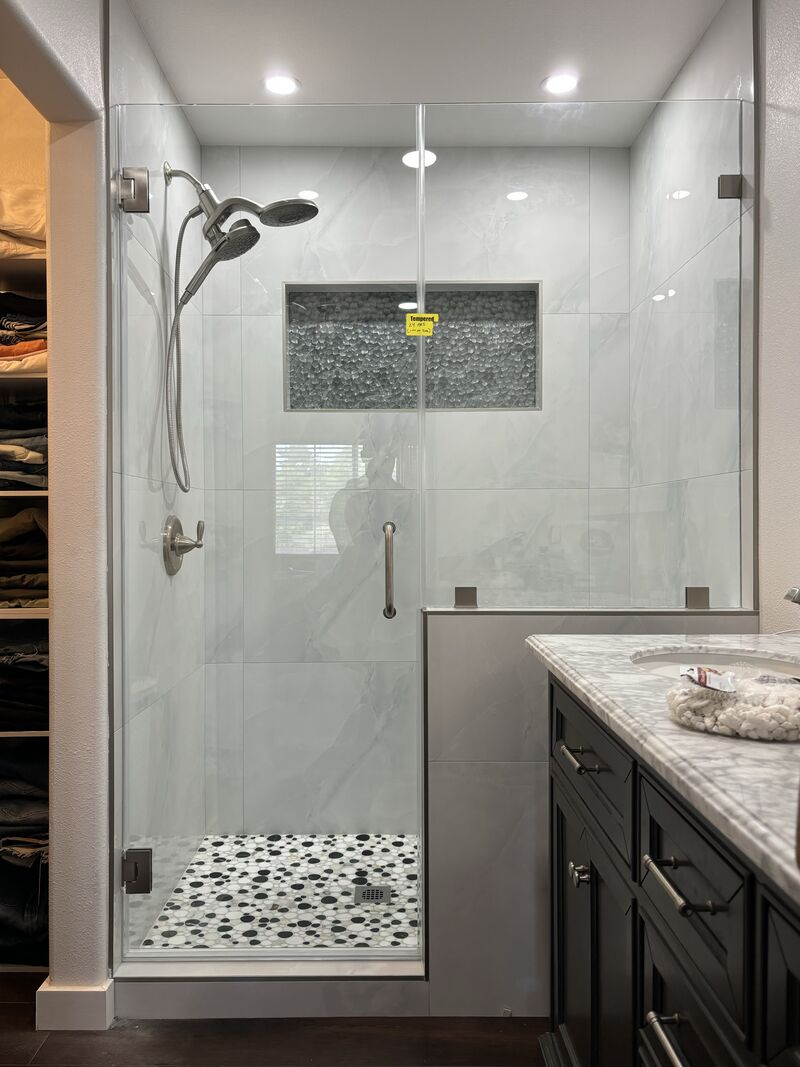 Frameless shower door and fixed inline glass above a pony wall in Chula Vista