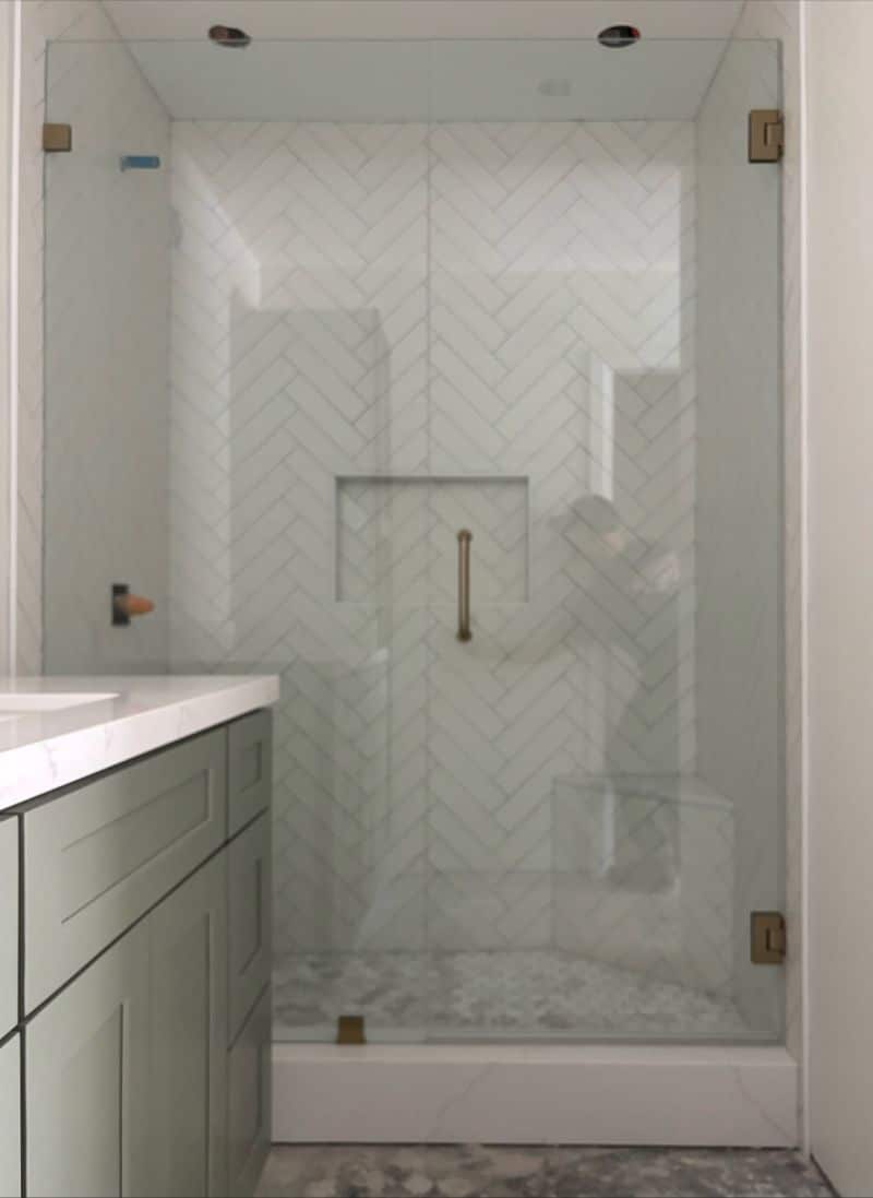 Door-and-inline shower enclosure with brushed bronze champagne hardware in Encinitas