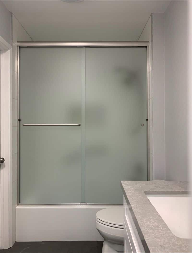Frosted bypass sliding shower enclosure on an acrylic tub in Escondido