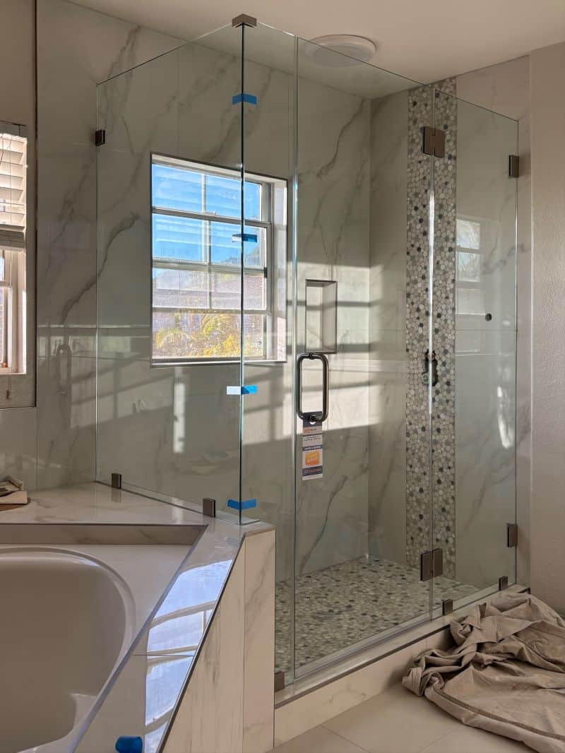 Corner shower on a pony wall with half-inch support glass and CWM clamps in Escondido