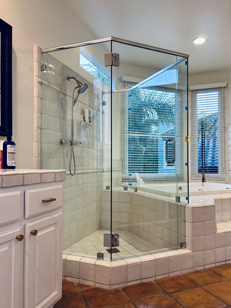 Five-piece frameless neo-angle shower enclosure with a header and decorative notches installed in Huntington Beach