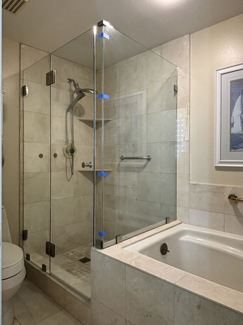 Frameless multi-panel corner shower enclosure on a tub deck with half-inch support glass in Huntington Beach