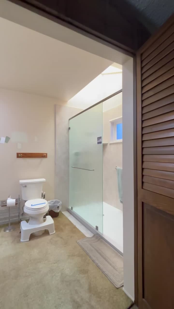Tall rain-glass splash panel with a top support header installed in Irvine