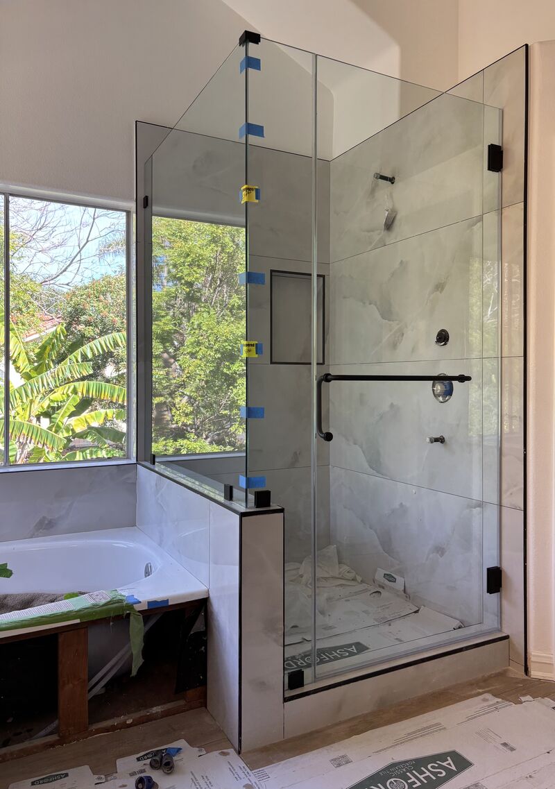 130-pound frameless corner shower enclosure on a pony wall with a towel-bar handle in Laguna Niguel
