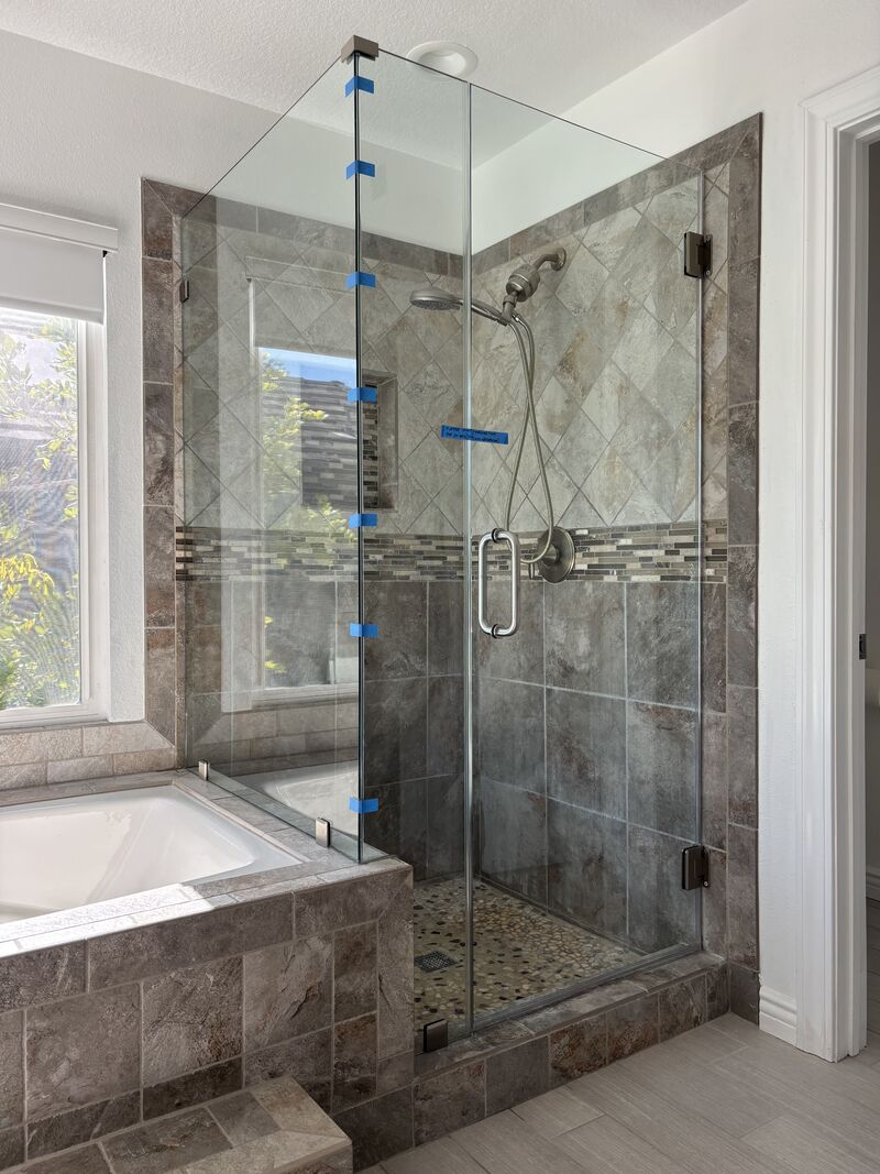 New frameless corner shower enclosure replacing stained shower glass in Laguna Niguel