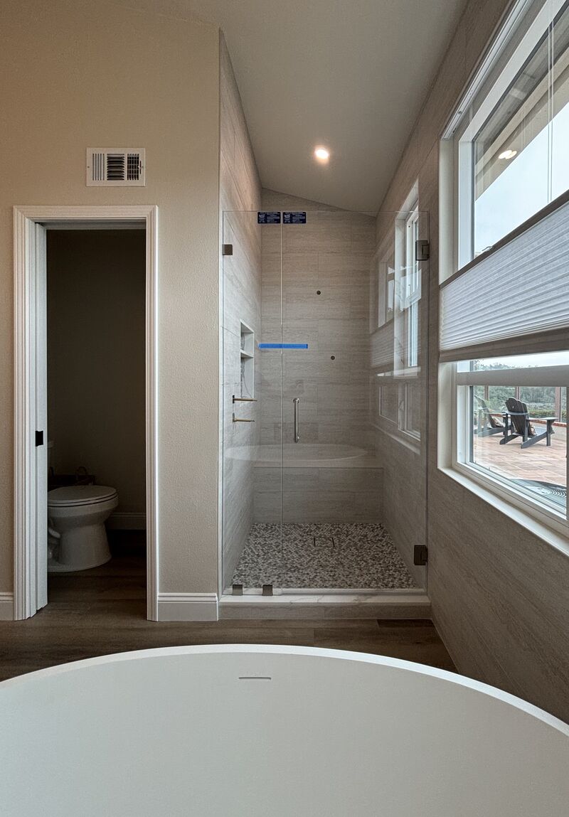 Opti-White low-iron frameless shower door with an inline panel installed in Laguna Niguel