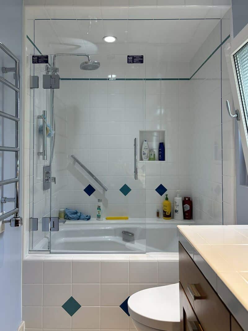 Opti-White low-iron swinging splash panel with half-inch support glass on a Laguna Niguel tub