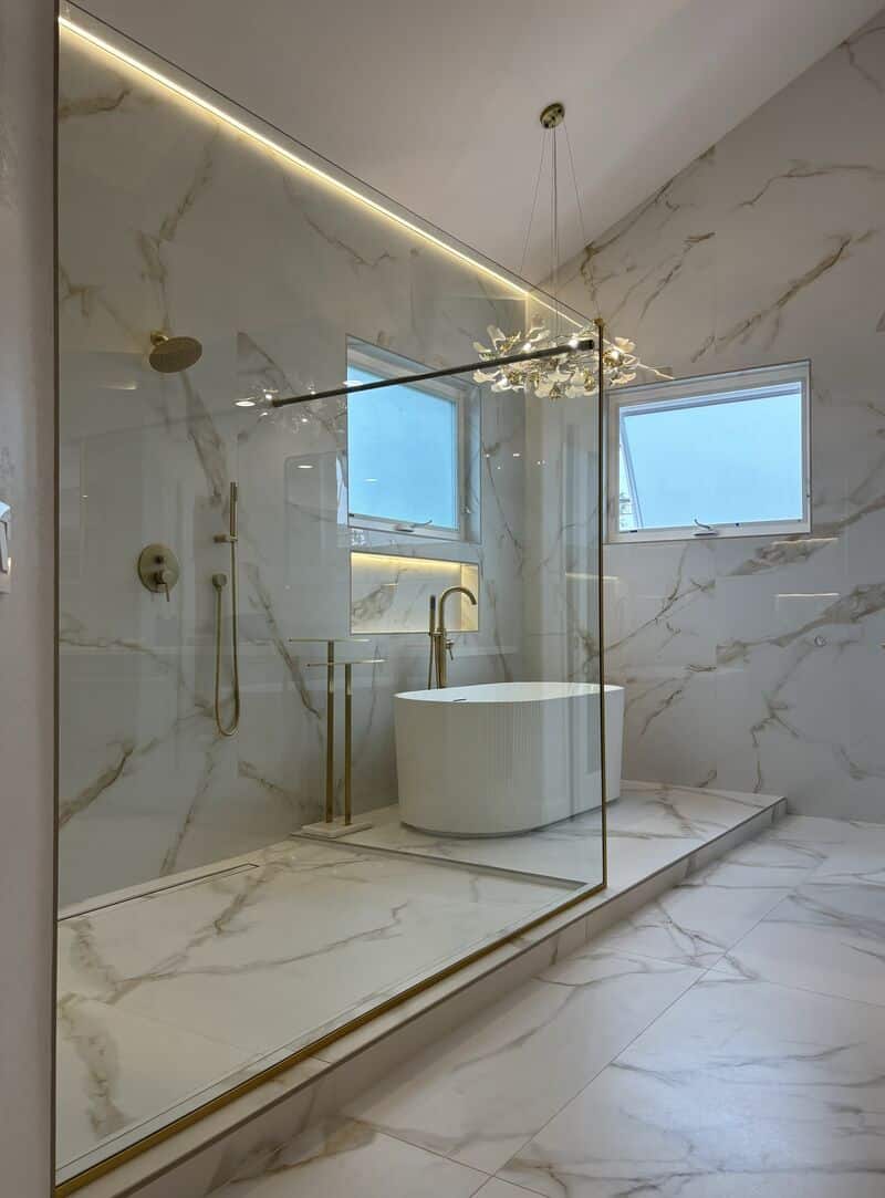 Large 220-pound shower splash panel in brushed-gold channel in Long Beach