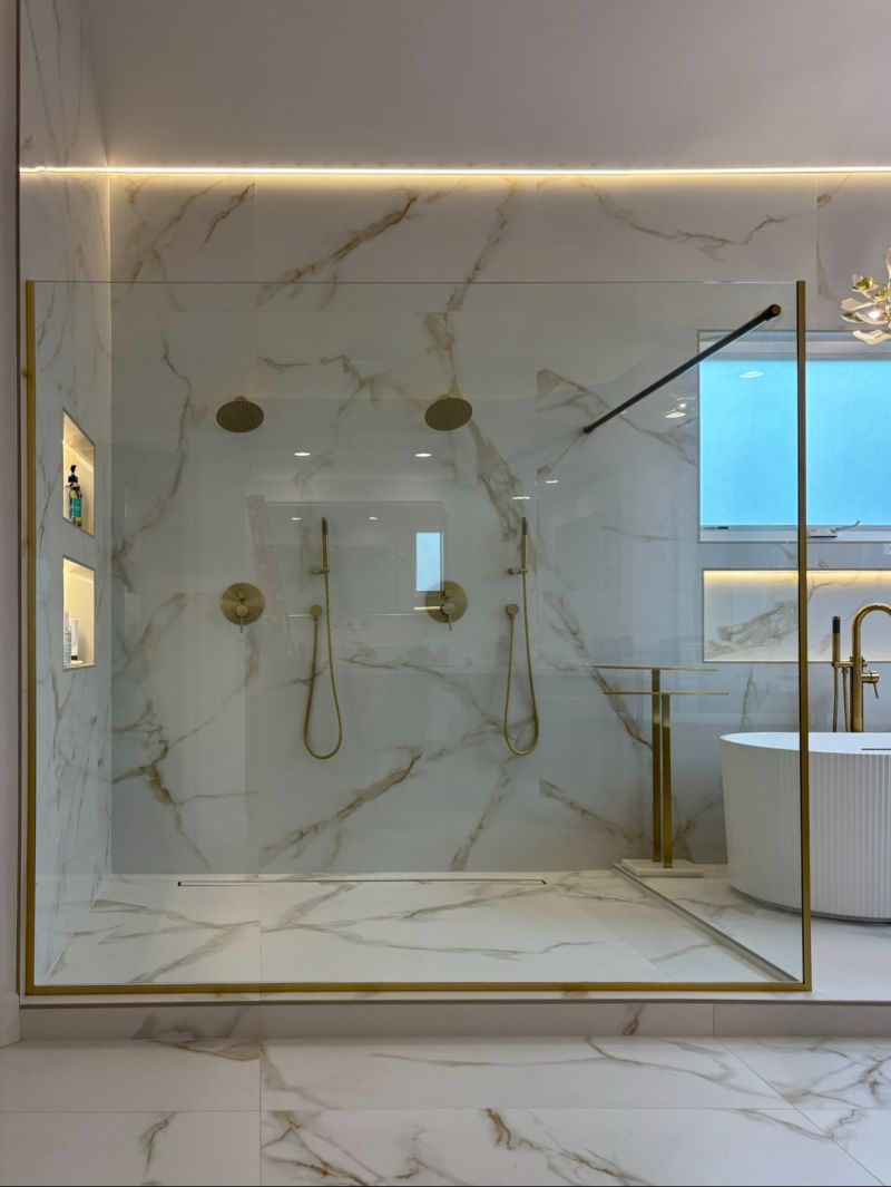 Finished 220-pound frameless splash panel in brushed-gold channel in Long Beach
