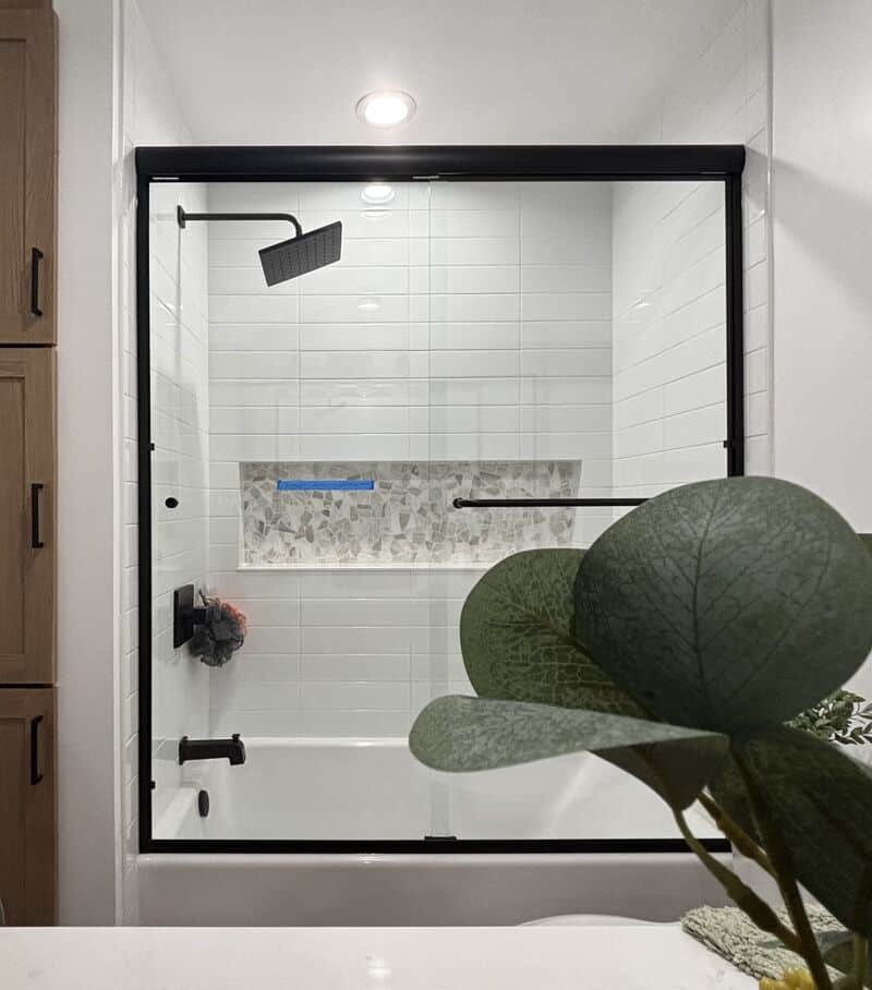 Matte-black bypass sliding glass enclosure on an acrylic tub in Long Beach
