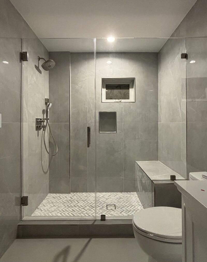 Frameless shower door and half-inch inline panel notched for a bench in Sherman Oaks, Los Angeles