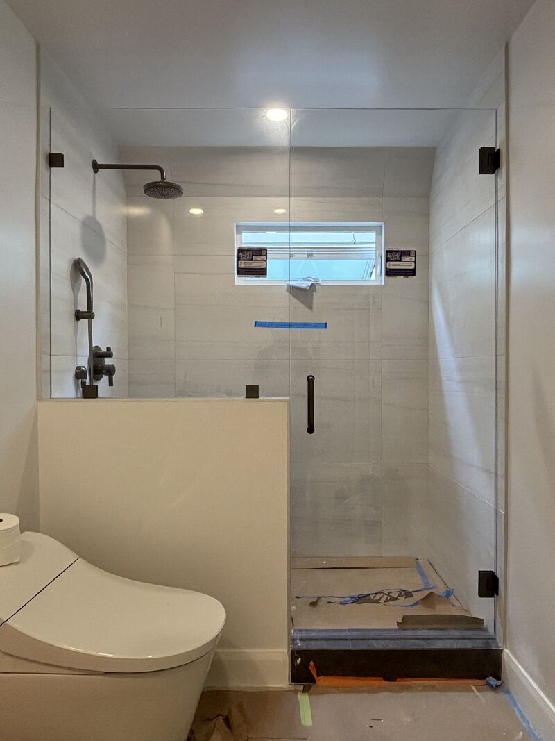 Frameless inline shower door with CRL gunmetal hardware in Manhattan Beach