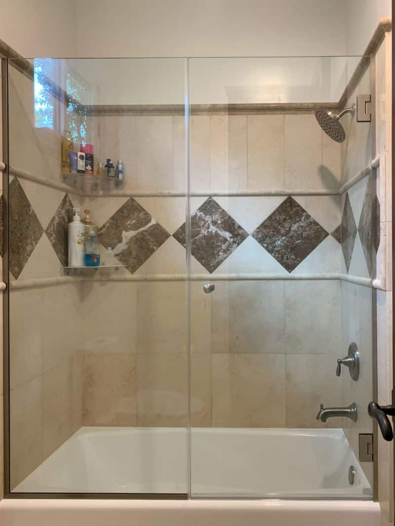 Frameless door and inline panel with decorative notches on steel tub in Manhattan Beach