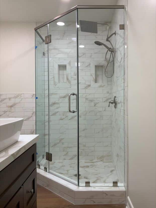 Four-panel neo-angle frameless shower enclosure with a header installed in Newport Beach