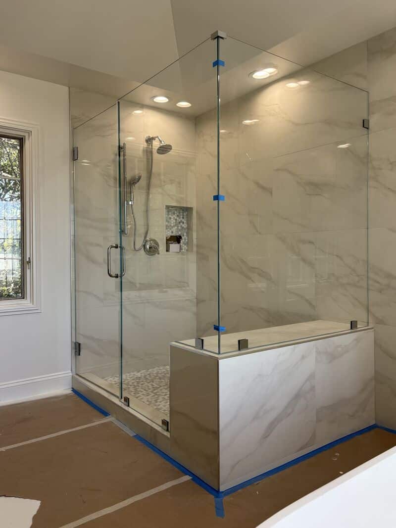 Half-inch Opti-White low-iron corner shower enclosure fitted to a bench in Newport Beach