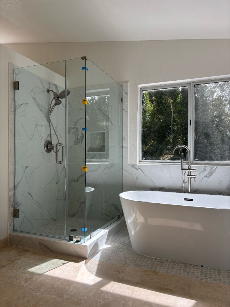 Clear corner shower beside a freestanding tub in Oceanside