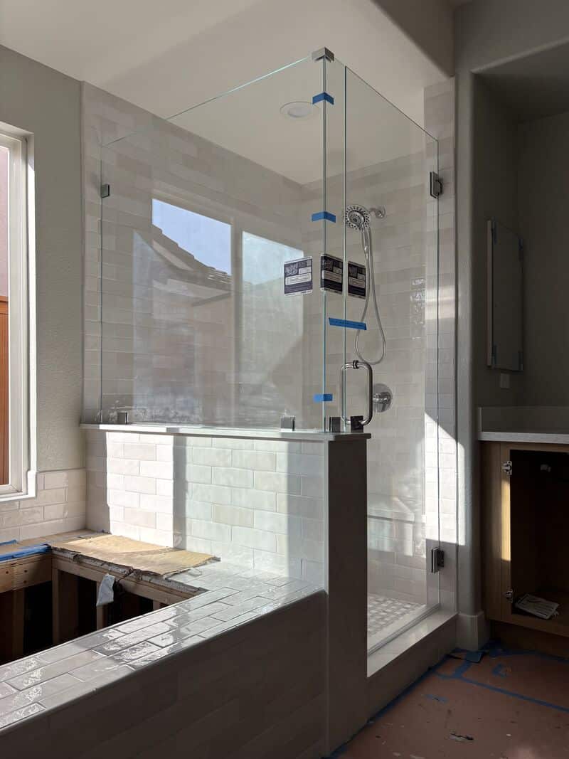 Opti-White low-iron corner shower on a pony wall treated with EnduroShield in Oceanside