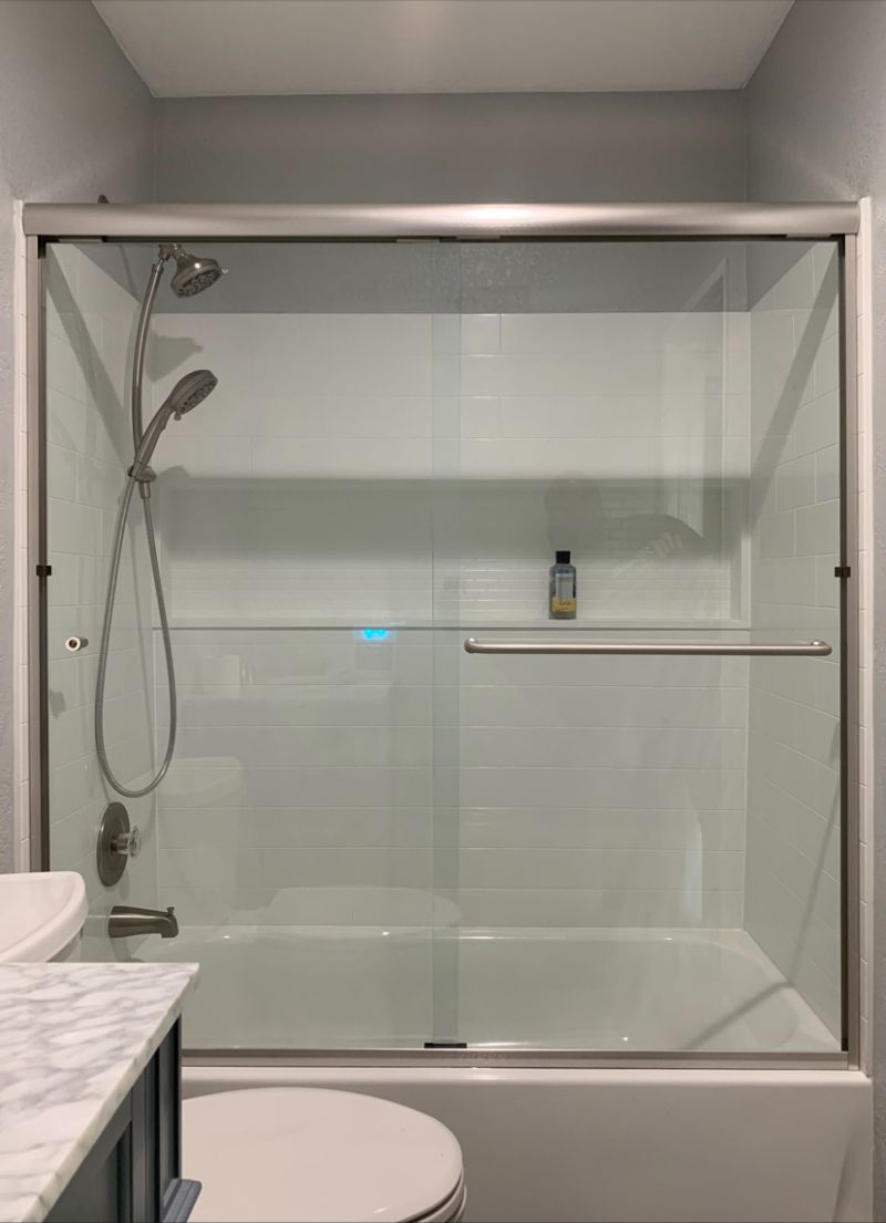 Bypass sliding enclosure installed on a steel tub in Oceanside