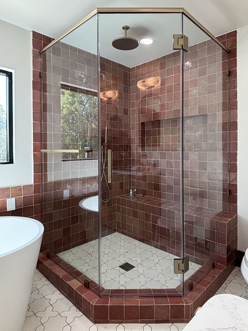 Brushed-bronze neo-angle shower showing header and glass-to-glass hinges in Pasadena