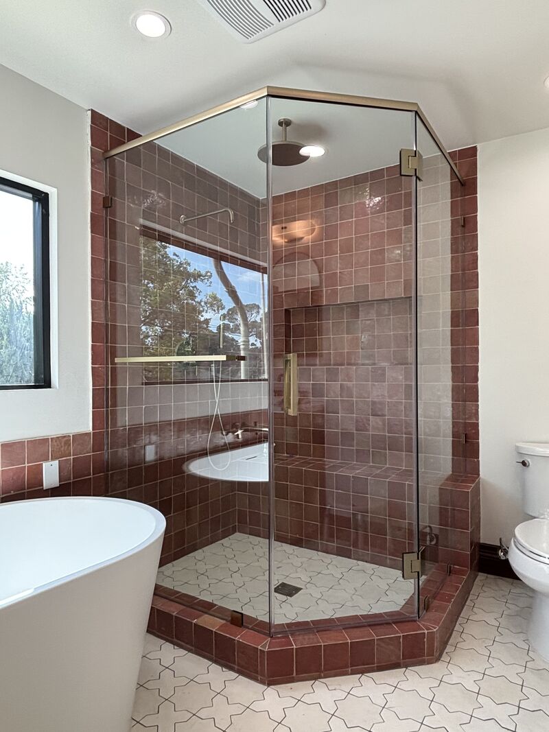 Finished neo-angle shower enclosure with FHC brushed-bronze hardware in Pasadena