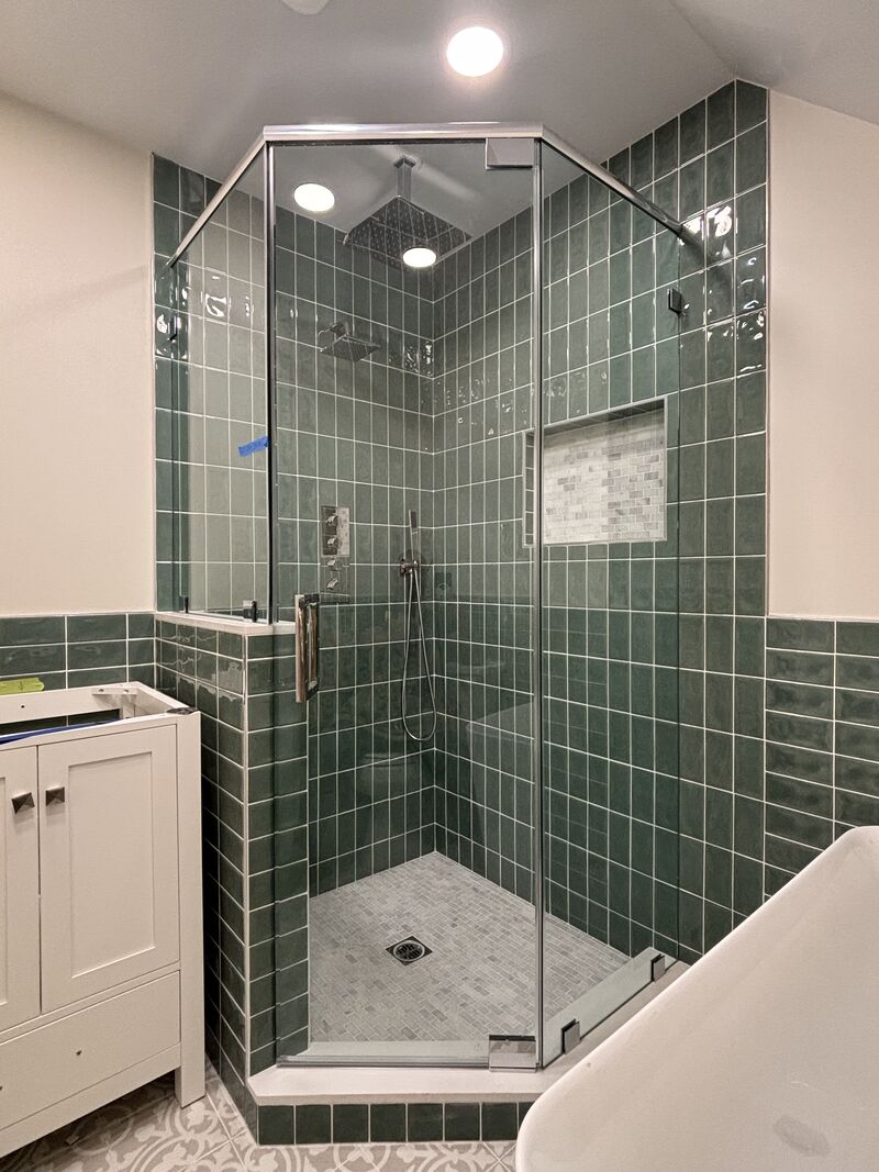 Neo-angle shower enclosure on a pony wall with header and pivot hinges in Pasadena