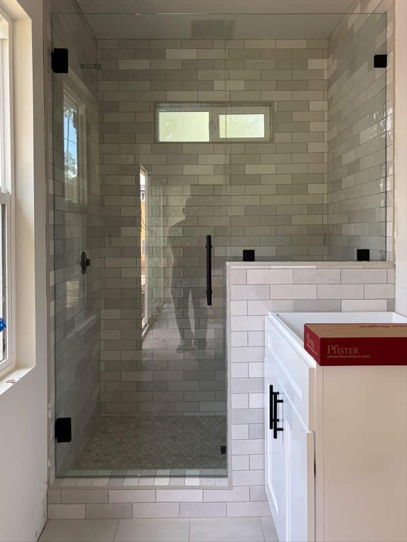 In-and-out swinging shower door with inline glass on a pony wall in Pasadena