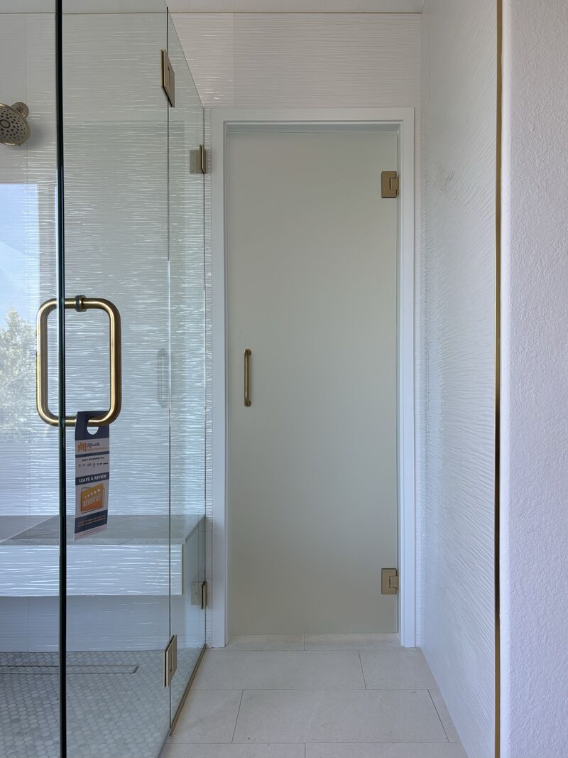 Front view of a frosted privacy-glass shower door in a custom curbless enclosure