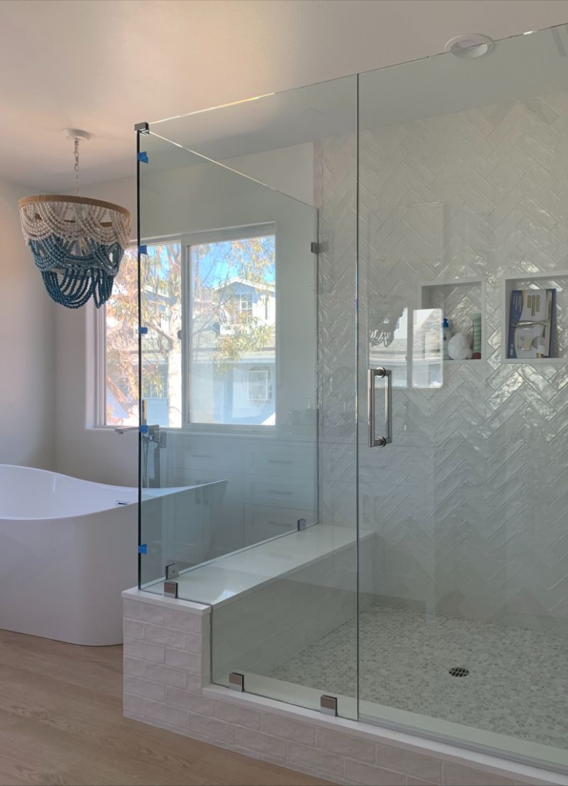 In-and-out swinging corner shower enclosure with bench and notched inline glass in Redondo Beach