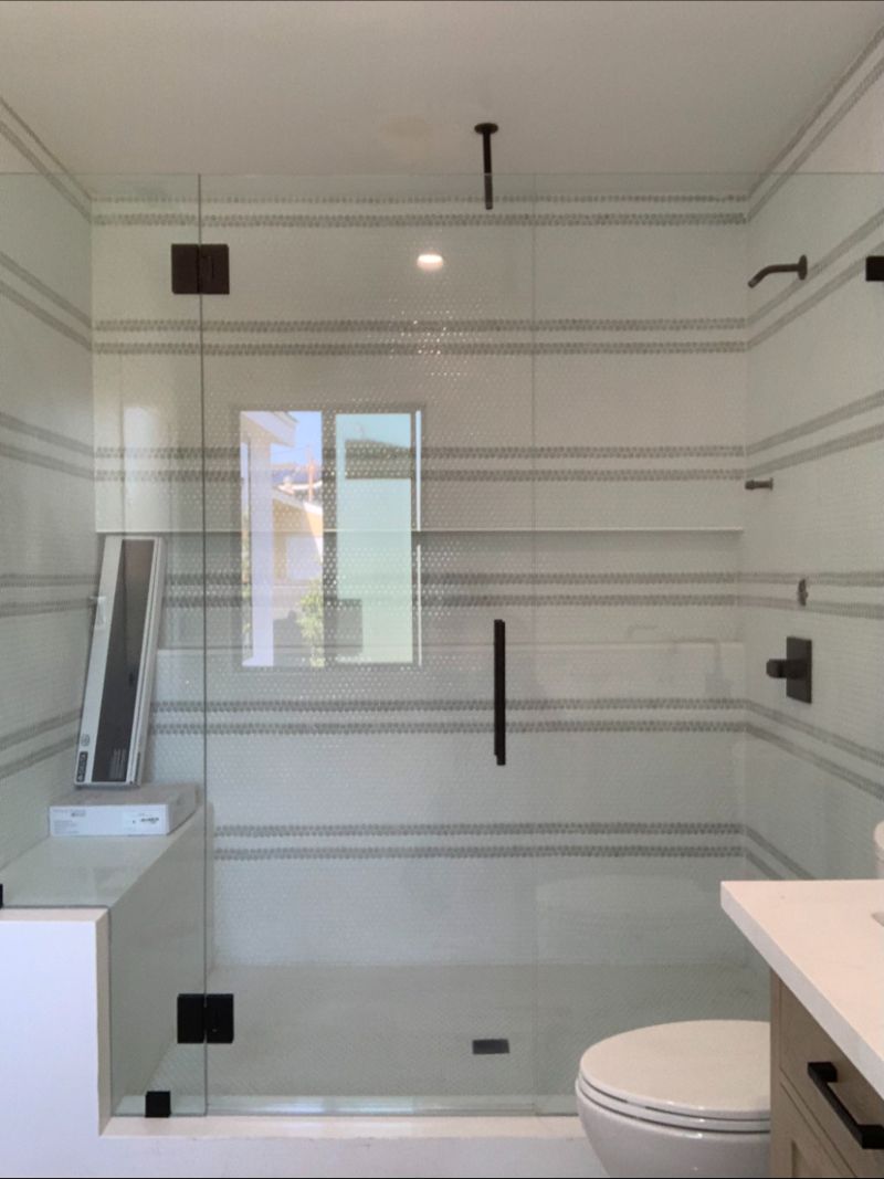 Shower enclosure with bench-notched half-inch support panel and glass-to-glass hinges in Redondo Beach