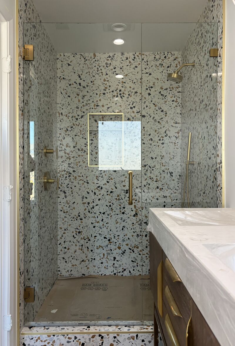 In-and-out swinging door and inline glass with brushed-gold hardware in San Diego