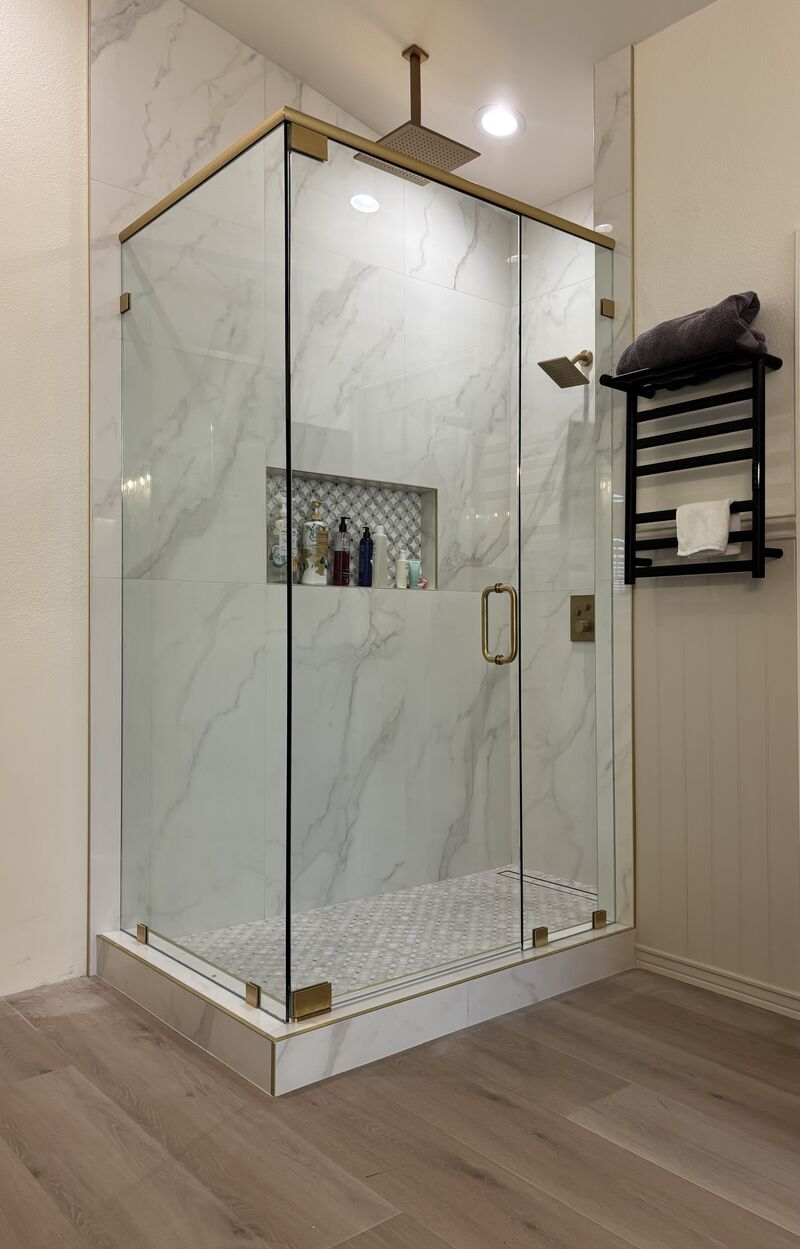 Corner shower with CRL brushed-gold header and pivot hinges in San Diego