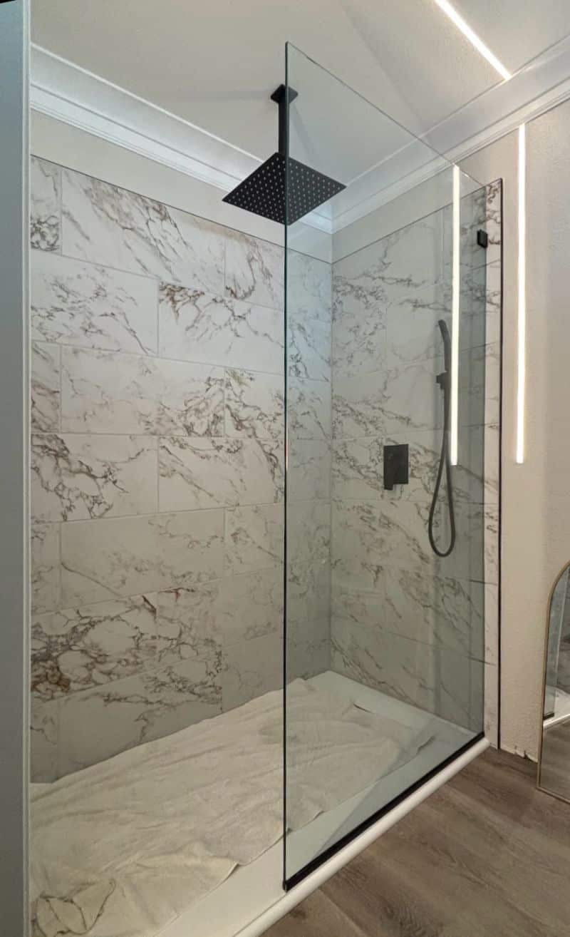Oversized fixed splash panel in channel on a molded shower pan in San Diego