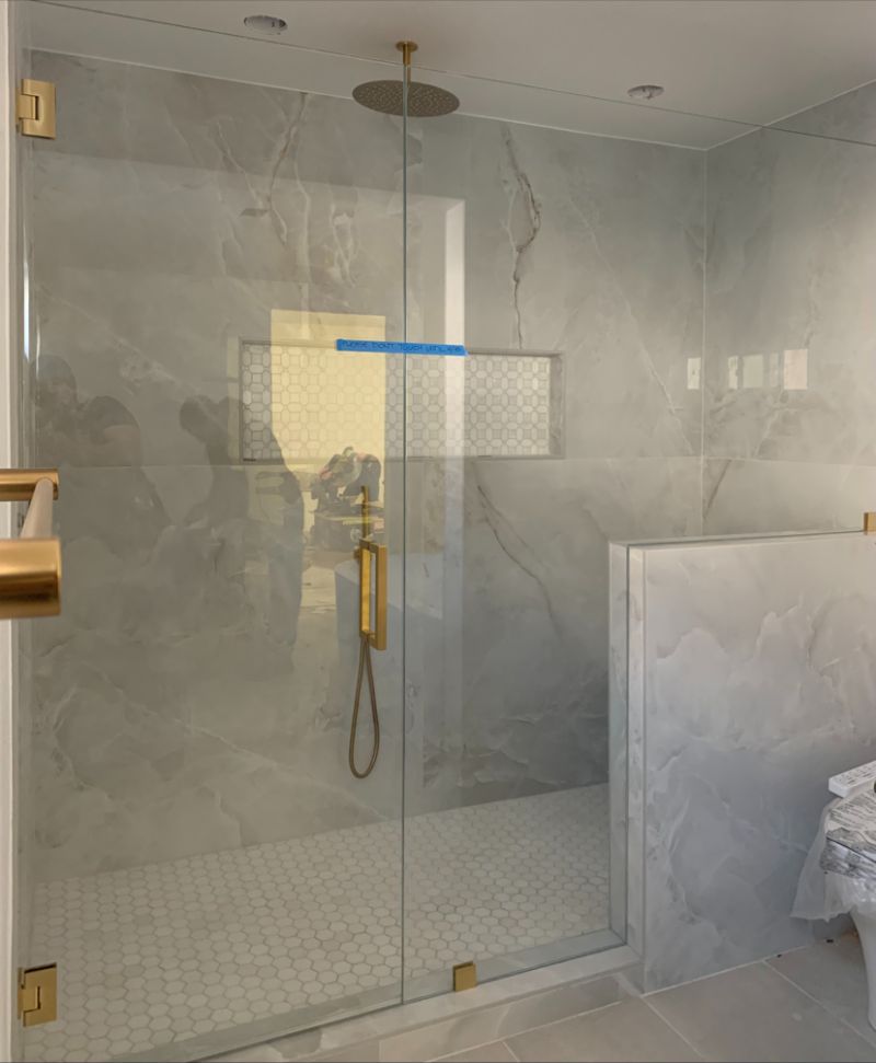 Half-inch Starphire shower glass with a 226-pound inline panel and satin-brass hardware in Torrance