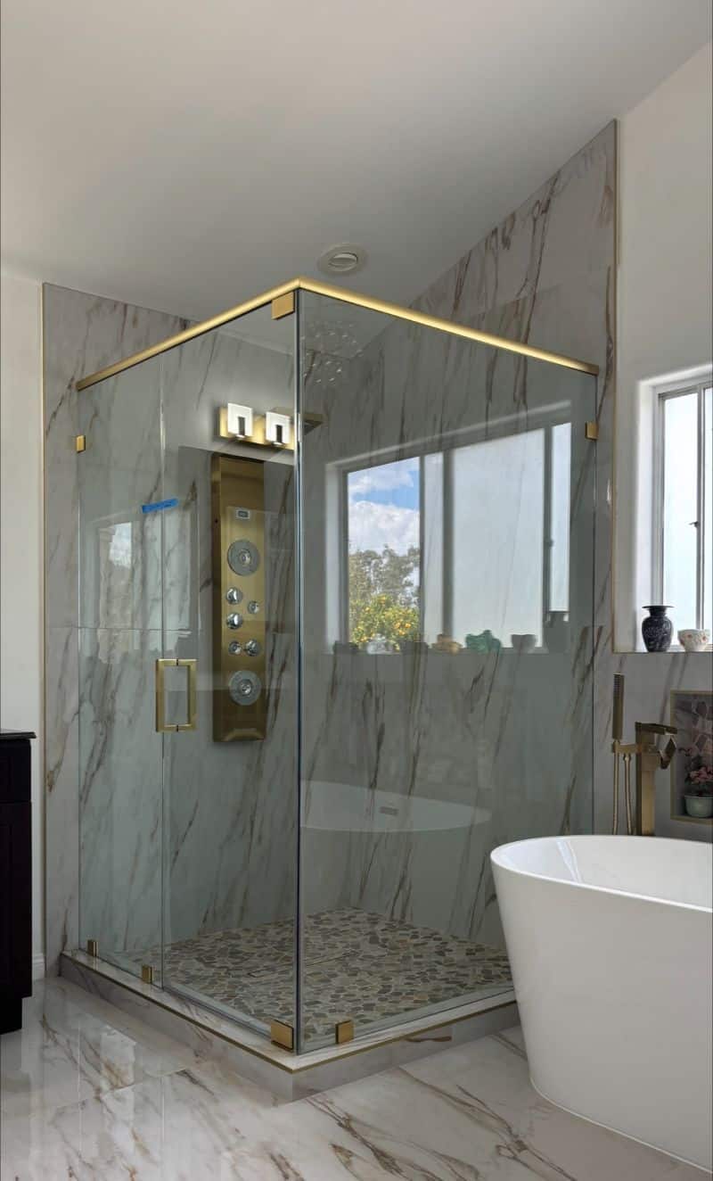 Brushed-gold corner enclosure with header and pivot hinges in Torrance